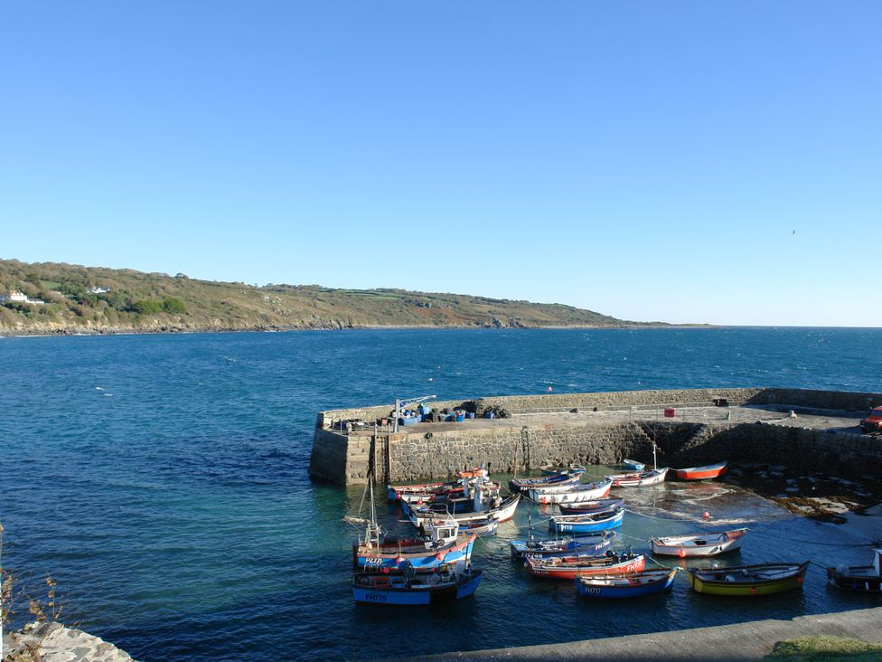 A harbor with boats docked and hills in the background at The Mariners in Coverack