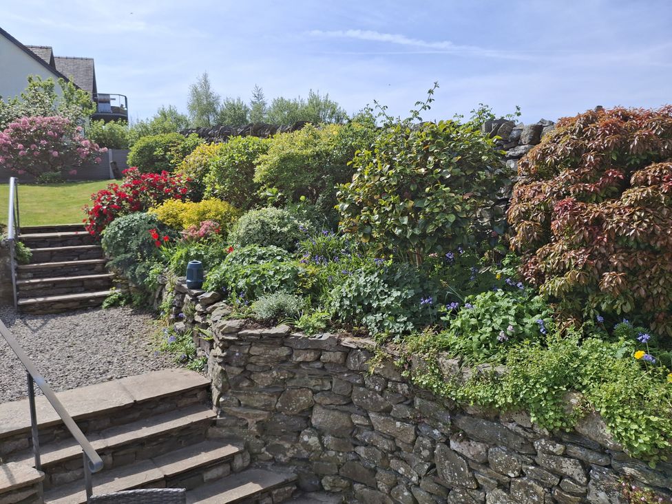 A garden with a stone wall and plants at Horse and Farrier Barn Newton in Cartmel near Cartmel