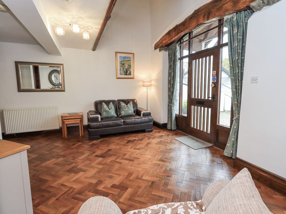 A living room with a sofa and lamp at Horse and Farrier Barn in Newton in Cartmel near Cartmel