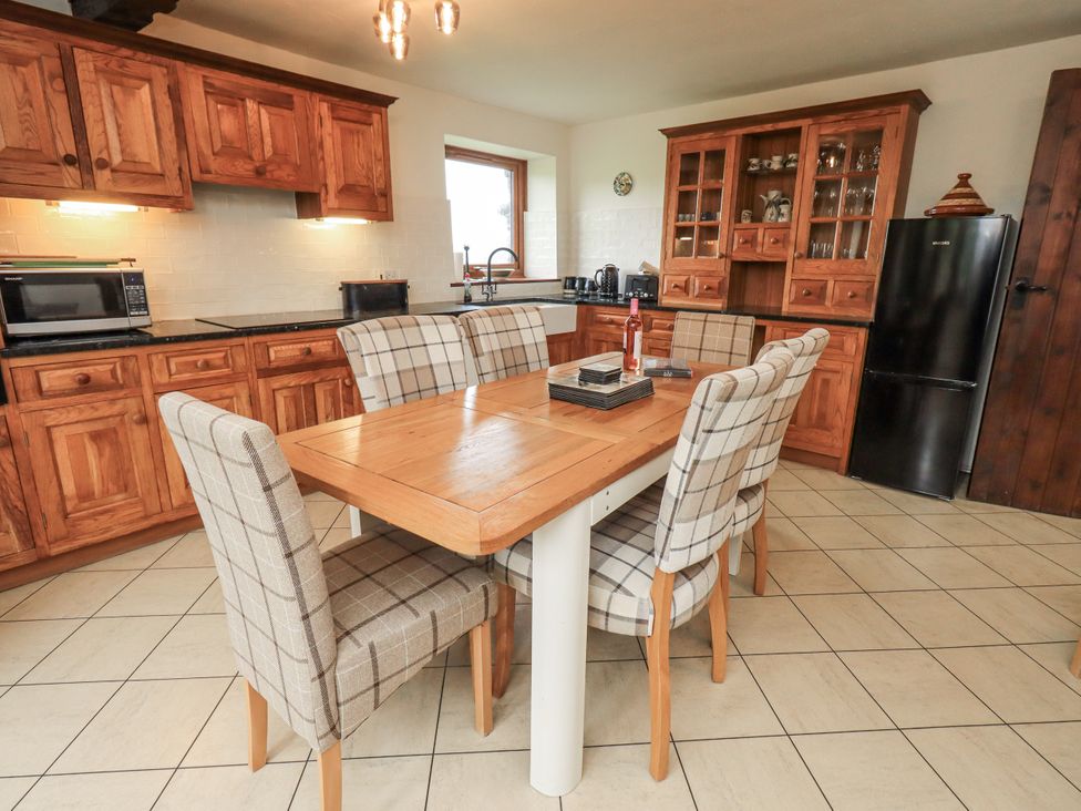 A kitchen with a dining table and chairs at Horse and Farrier Barn in Newton in Cartmel near Cartmel