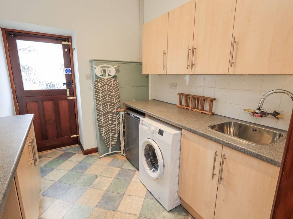 A kitchen with a washing machine and a sink at Horse and Farrier Barn, Newton in Cartmel near Cartmel