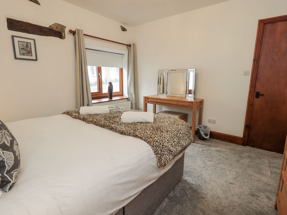 A bedroom with a bed and a mirror at Horse and Farrier Barn in Newton in Cartmel near Cartmel