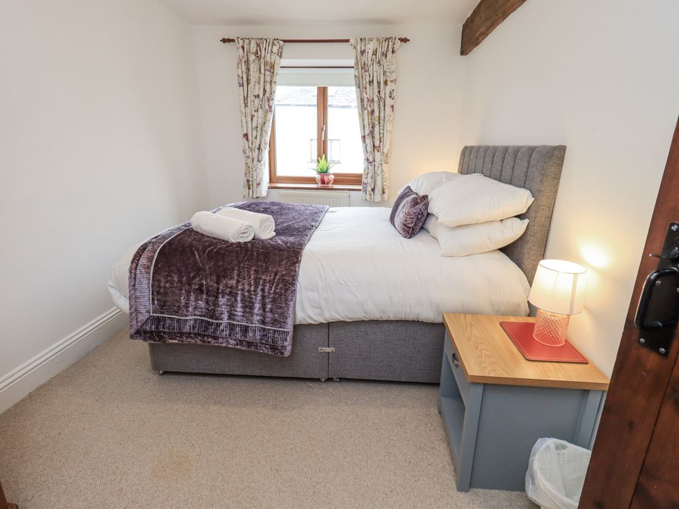 A bedroom with a bed and window at Horse and Farrier Barn in Newton in Cartmel near Cartmel