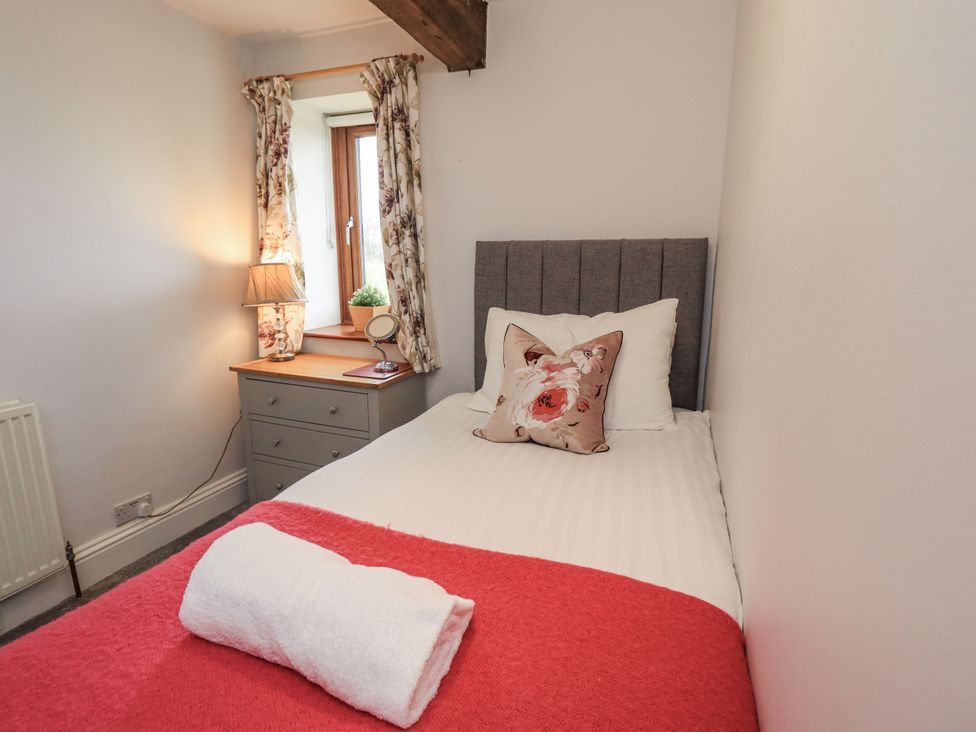 A bedroom with a bed and a nightstand at Horse and Farrier Barn in Newton in Cartmel near Cartmel