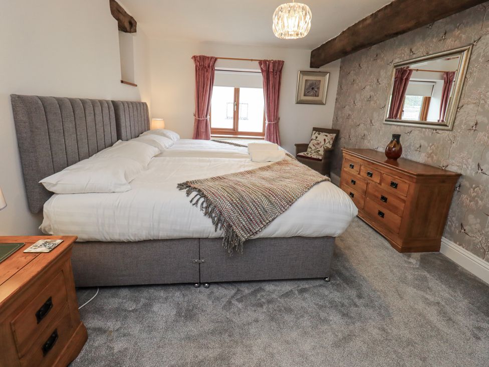 A bedroom with a bed and dresser at Horse and Farrier Barn, Newton in Cartmel near Cartmel