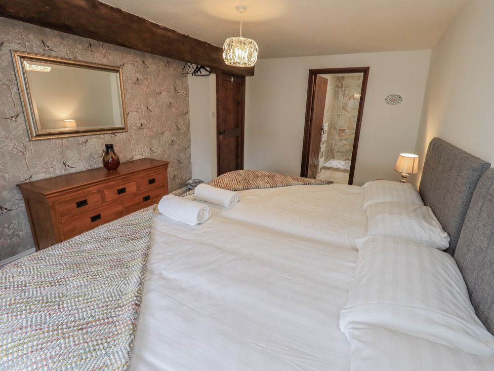 A bedroom with two beds and a dresser at Horse and Farrier Barn in Newton in Cartmel near Cartmel