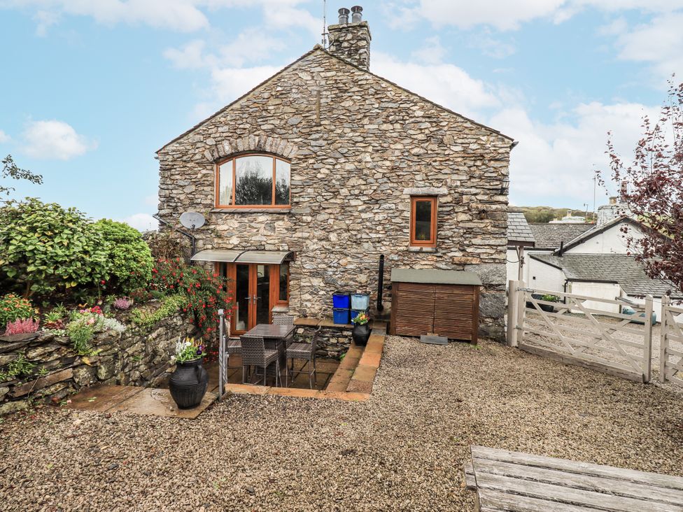 A stone house exterior with plants and a gravel area at Horse and Farrier Barn, Newton in Cartmel near Cartmel