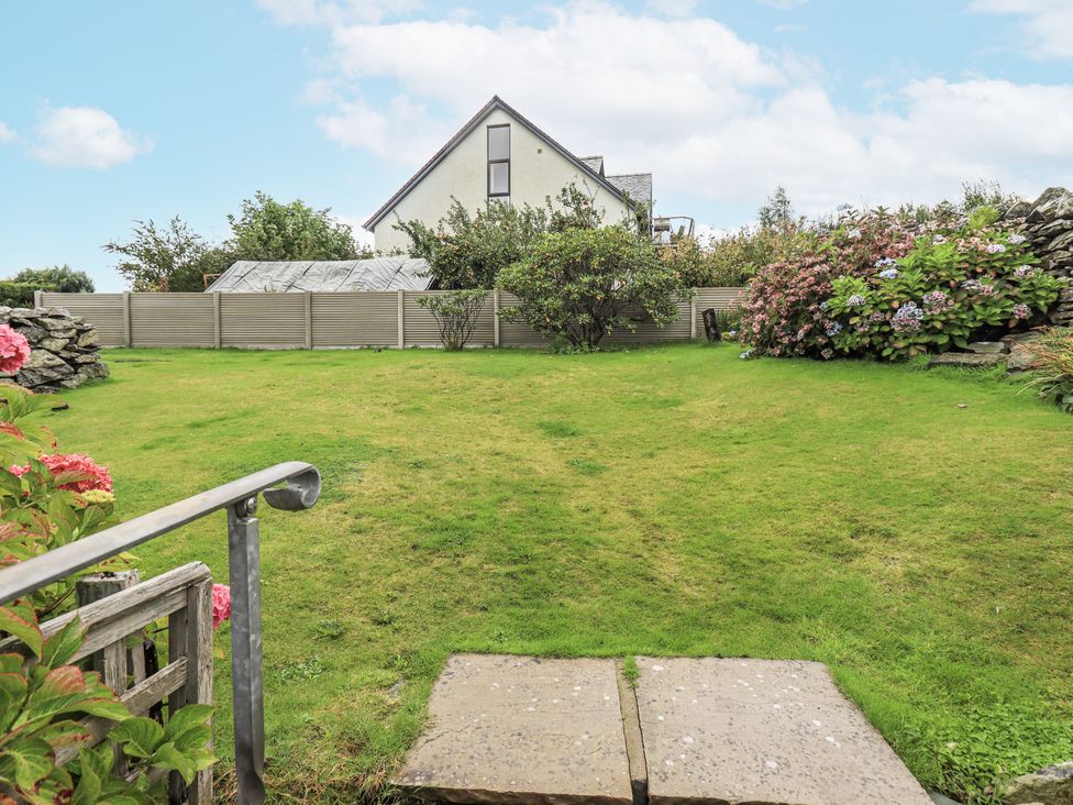 A garden with flower shrubs and a house in the background at Horse and Farrier Barn Newton in Cartmel near Cartmel
