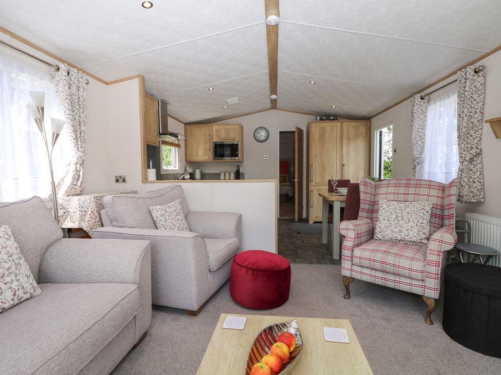 A living room with a sofa and dining table at 18 Deer Glade in Landford