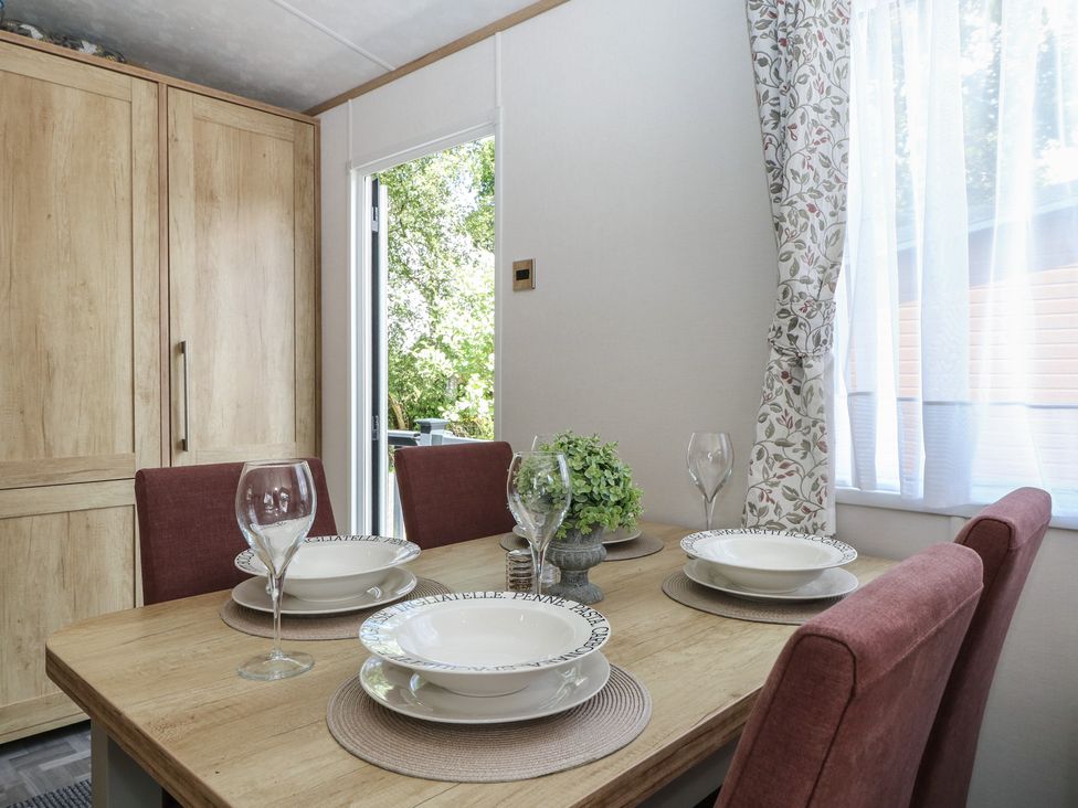 A dining room with a table set for meals at 18 Deer Glade in Landford