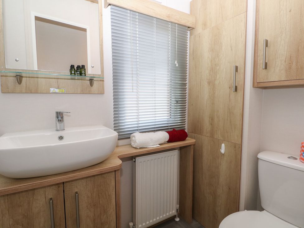 A bathroom with a sink, toilet, and towels at 18 Deer Glade in Landford