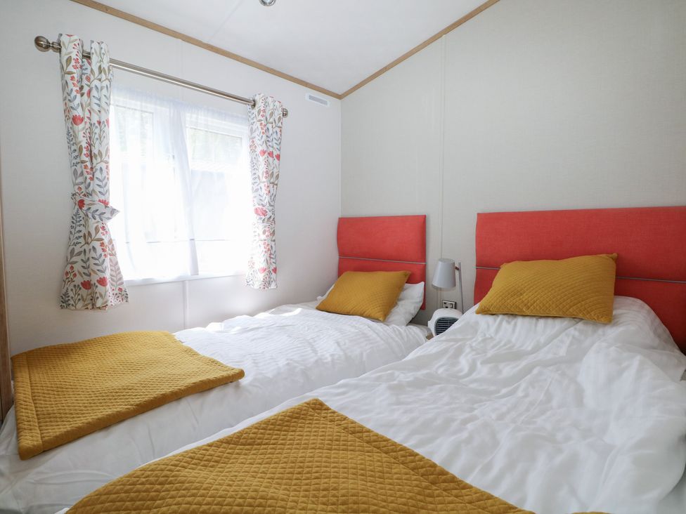 A bedroom with twin beds and a window at 18 Deer Glade in Landford