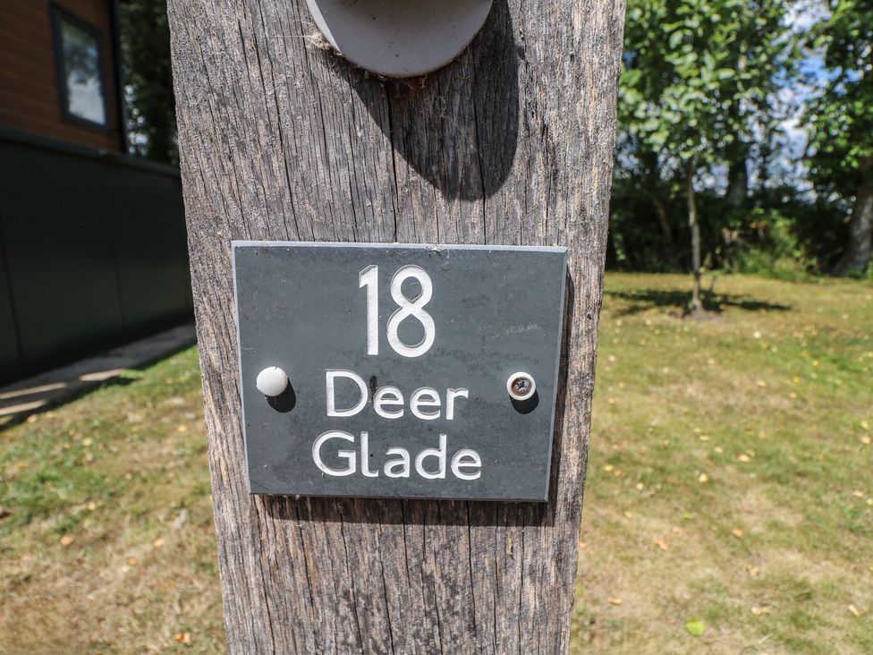 A sign with the number 18 and the name Deer Glade