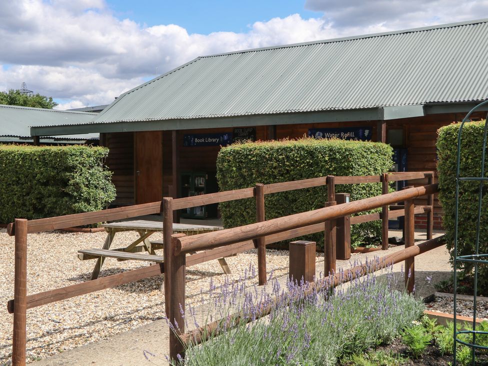 An outdoor area with a table and hedges at 18 Deer Glade in Landford