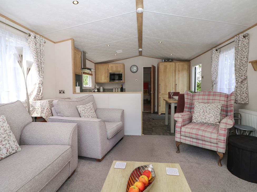 A living room with a sofa and armchair at 18 Deer Glade in Landford