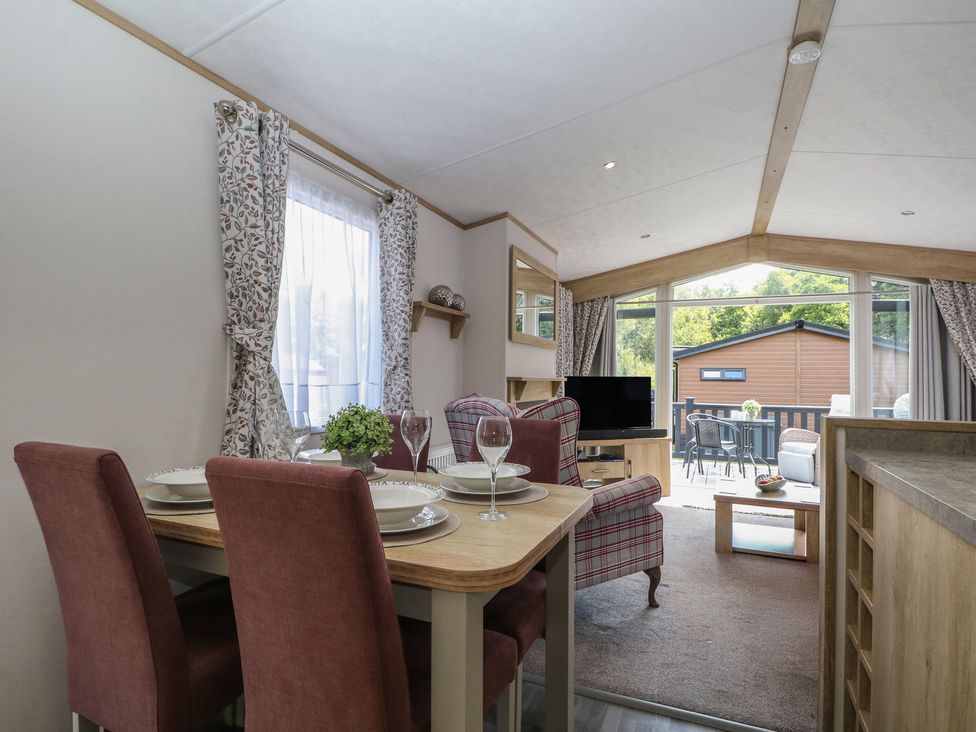 A living room with a dining area and television at 18 Deer Glade in Landford