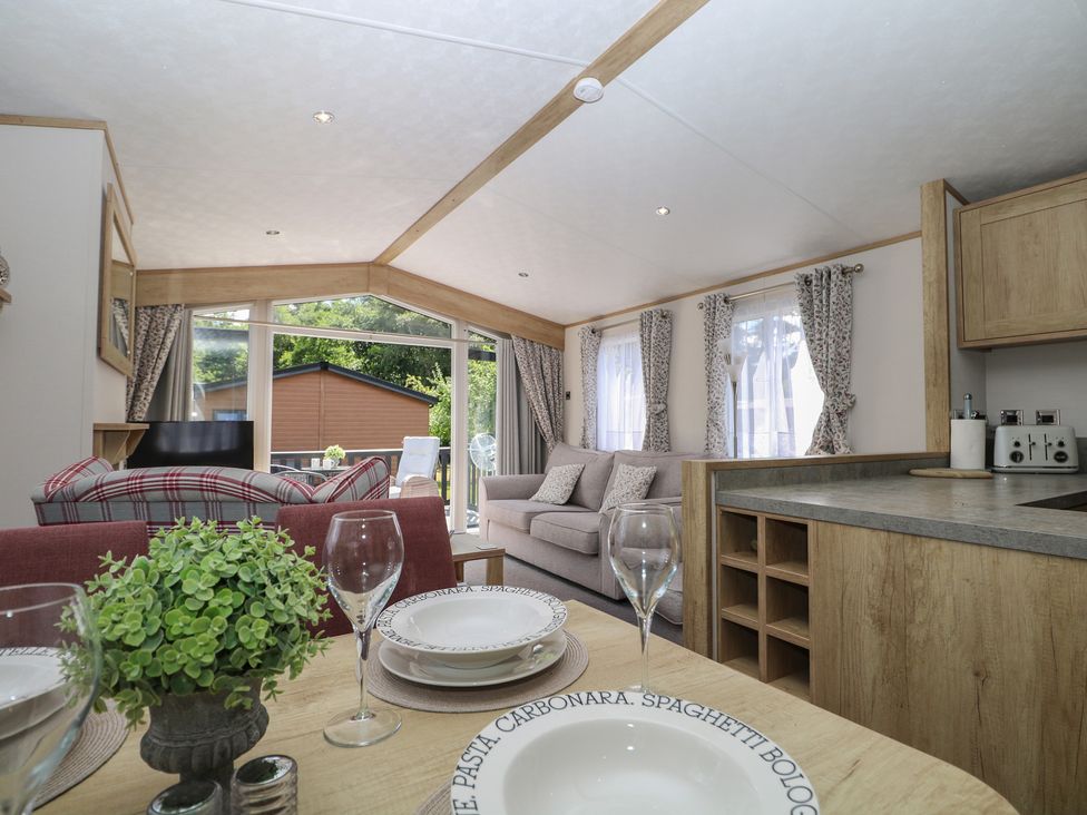 A living room with a sofa and dining table at 18 Deer Glade in Landford