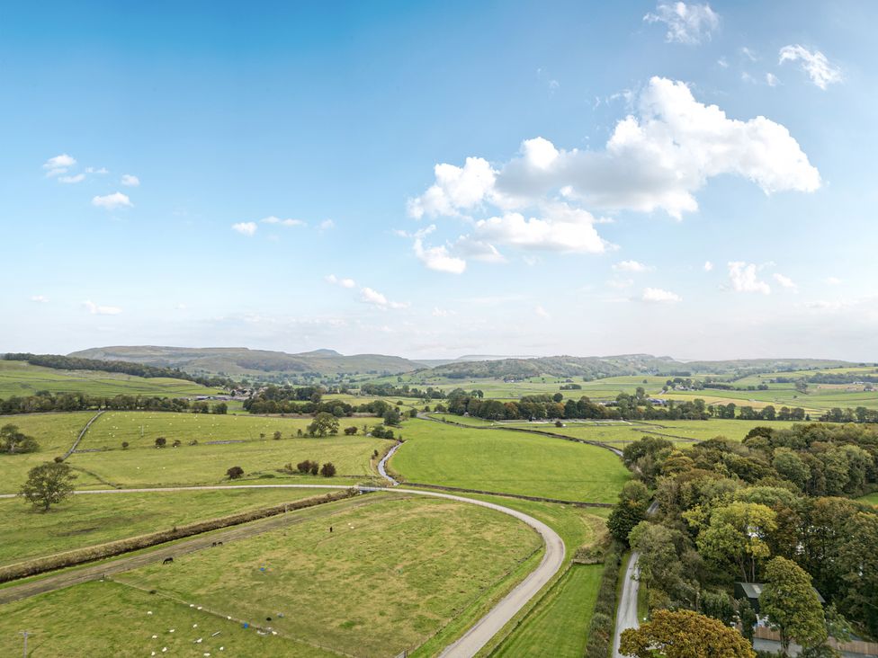 A landscape view of fields and hills at Orcaber Farmhouse in Austwick