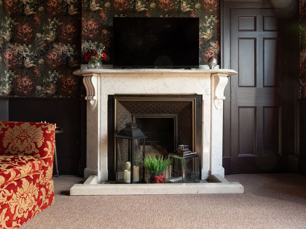 A sitting room with a fireplace and television at Wonderland in Tweedmouth, Berwick-Upon-Tweed