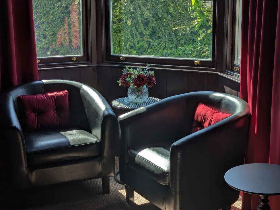 Two chairs and a table with flowers in a sitting room at Wonderland in Tweedmouth, Berwick-Upon-Tweed
