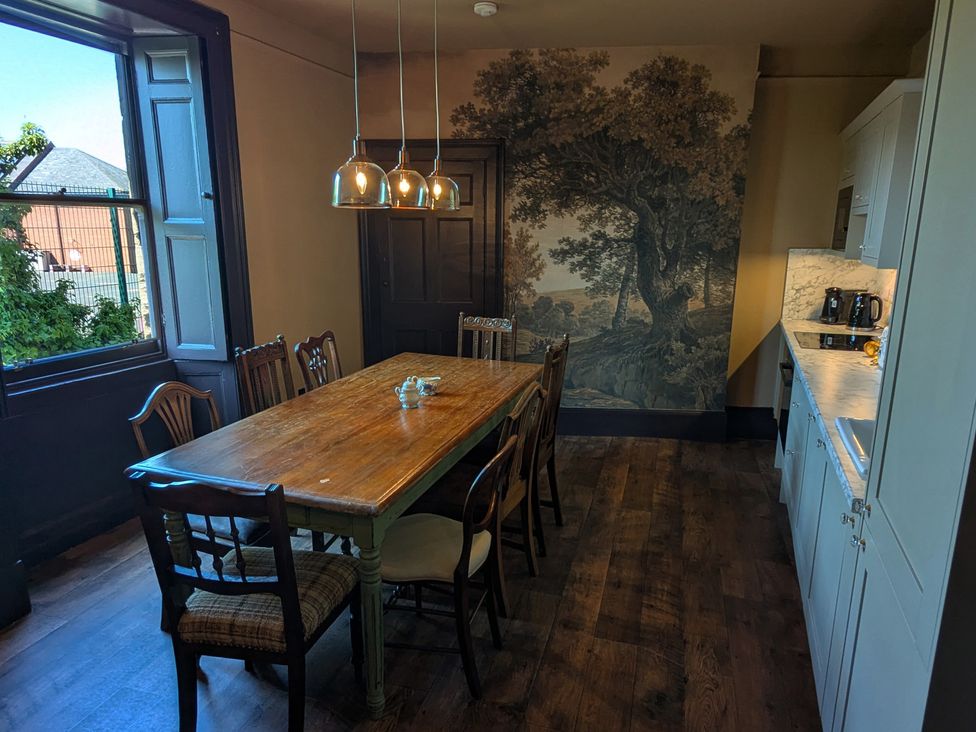 A dining room with a large table and chairs at Wonderland in Tweedmouth, Berwick-Upon-Tweed