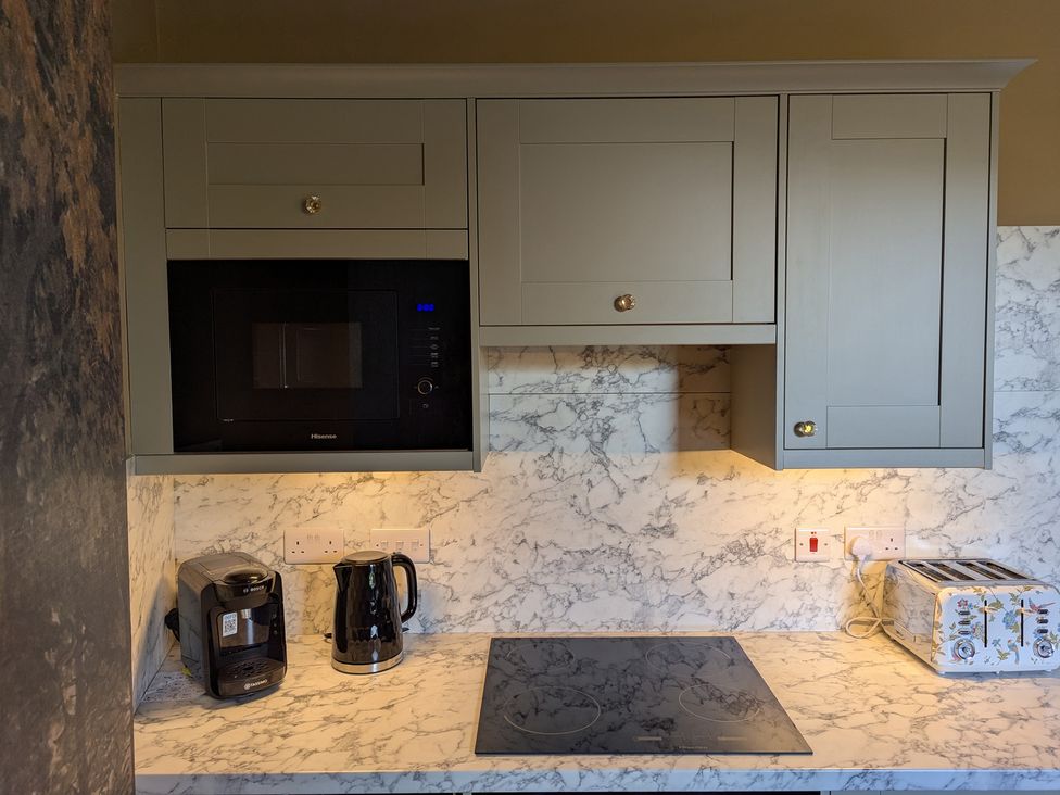 A kitchen with a microwave, kettle, coffee maker, and toaster at Wonderland, Tweedmouth, Berwick-Upon-Tweed