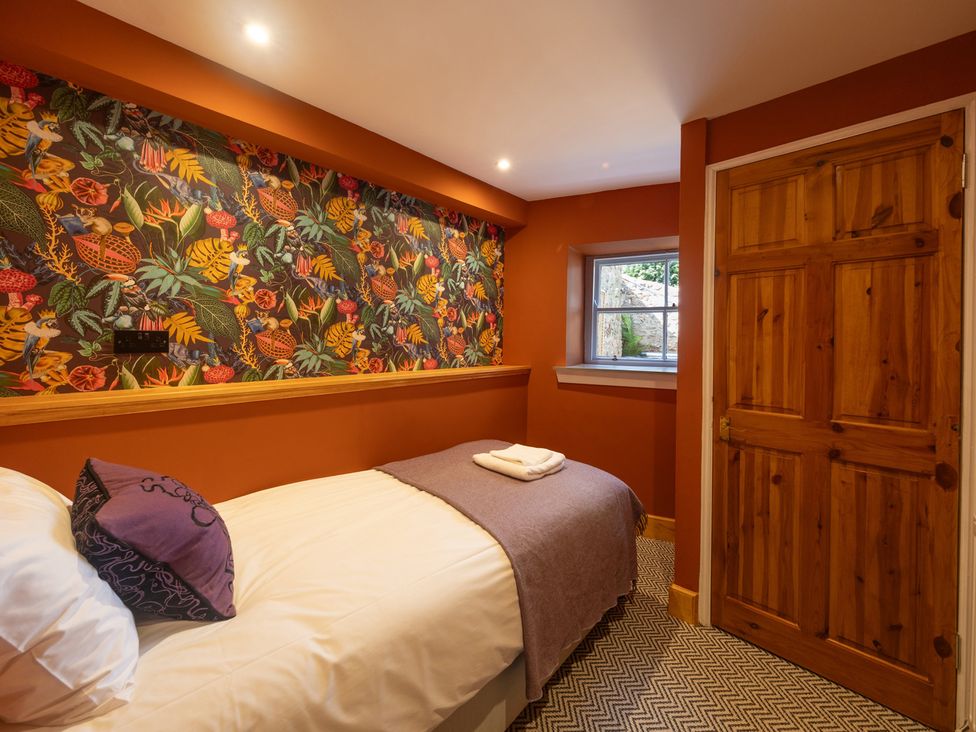 A bedroom with a bed and patterned wall at Wonderland in Tweedmouth, Berwick-Upon-Tweed
