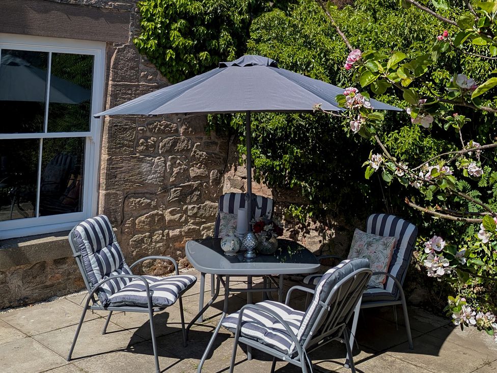 A garden seating area with a table and chairs at Wonderland in Tweedmouth, Berwick-Upon-Tweed