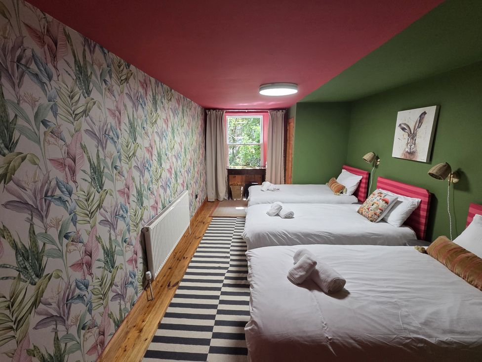 A bedroom with three beds and a window at Wonderland in Tweedmouth, Berwick-Upon-Tweed