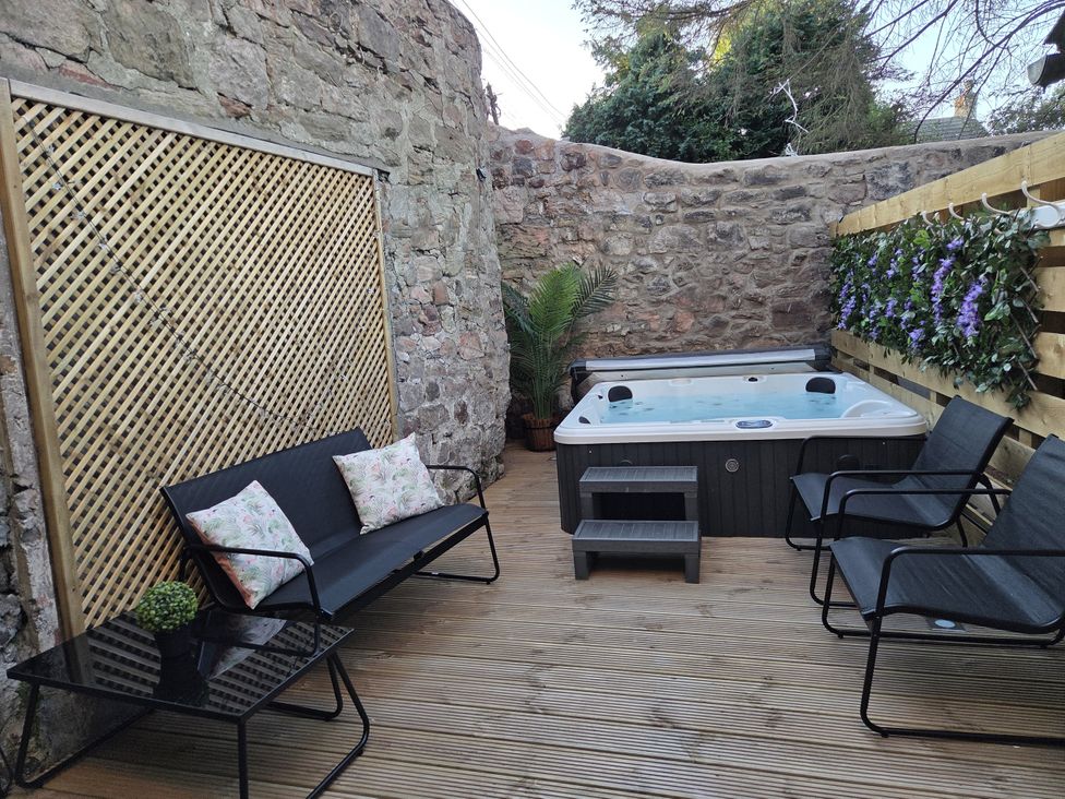 An outdoor area with a hot tub and seating at Wonderland in Tweedmouth, Berwick-Upon-Tweed