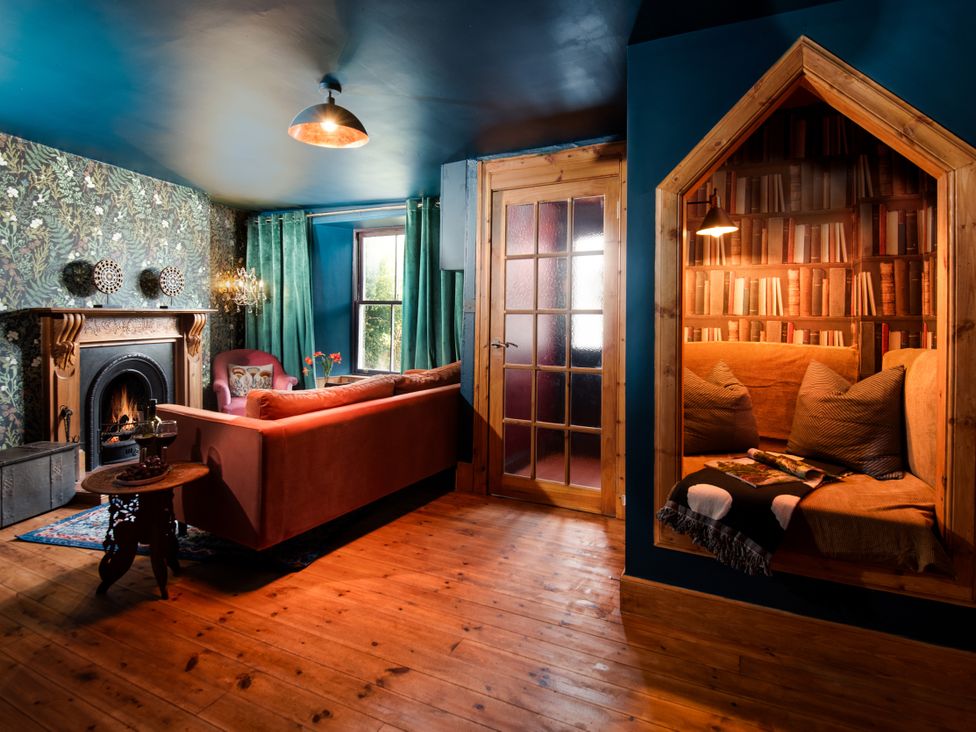 A living room with a fireplace and book nook at Wonderland in Tweedmouth, Berwick-Upon-Tweed