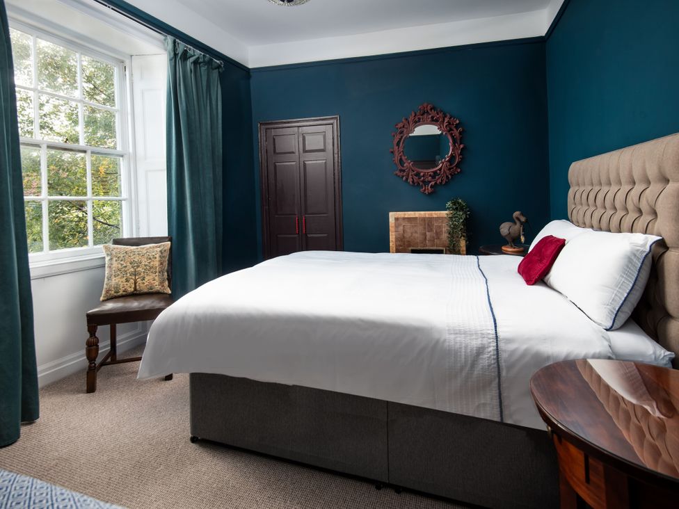 A bedroom with a bed and chair at Wonderland in Tweedmouth, Berwick-Upon-Tweed