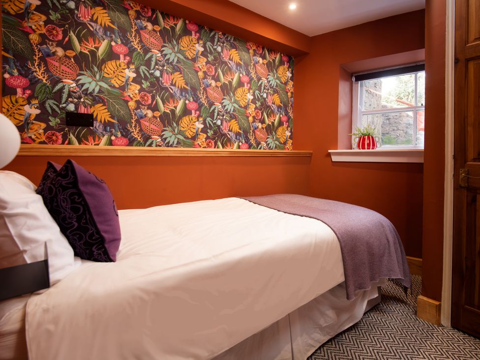 A bedroom with a bed and wallpaper at Wonderland in Tweedmouth, Berwick-Upon-Tweed