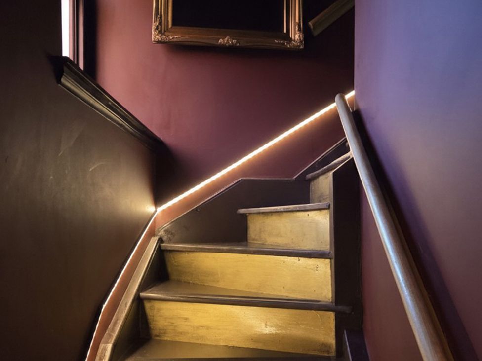 A staircase with wooden steps and wall decorations at Wonderland in Tweedmouth, Berwick-Upon-Tweed
