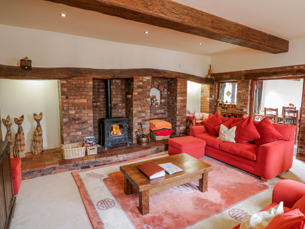 A living room with a stove and a wooden coffee table at The Haybarn in Lichfield