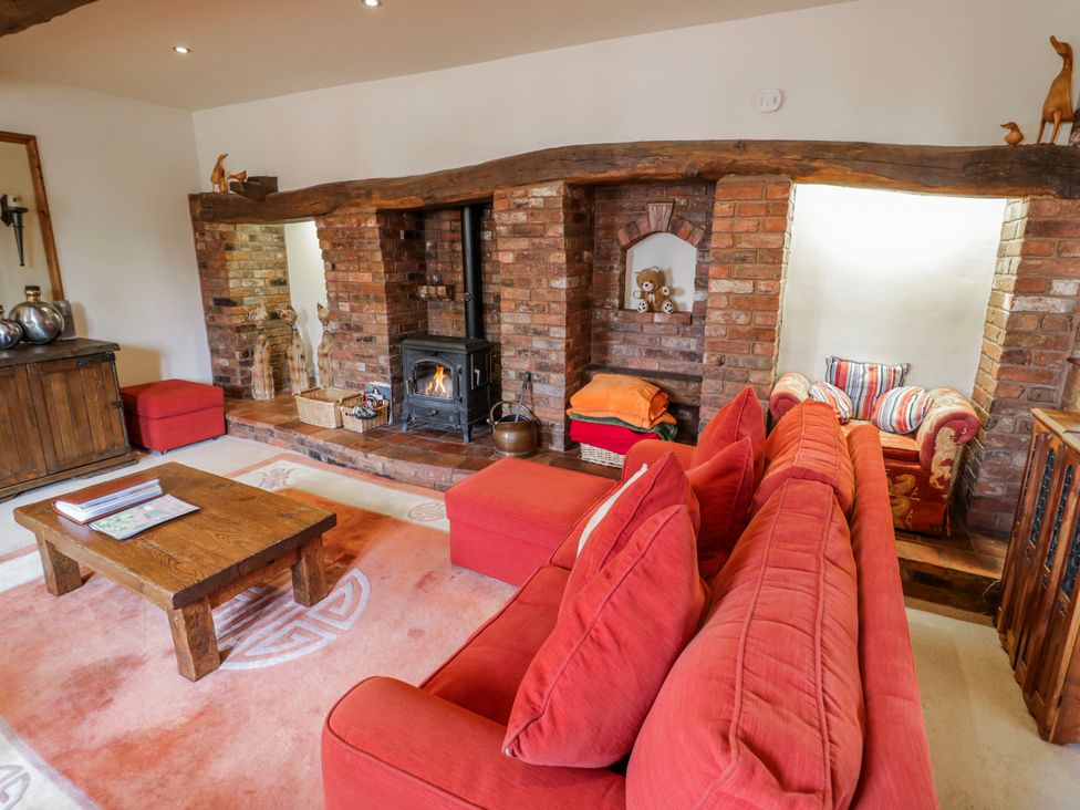 A living room with a fireplace and sofa at The Haybarn in Lichfield