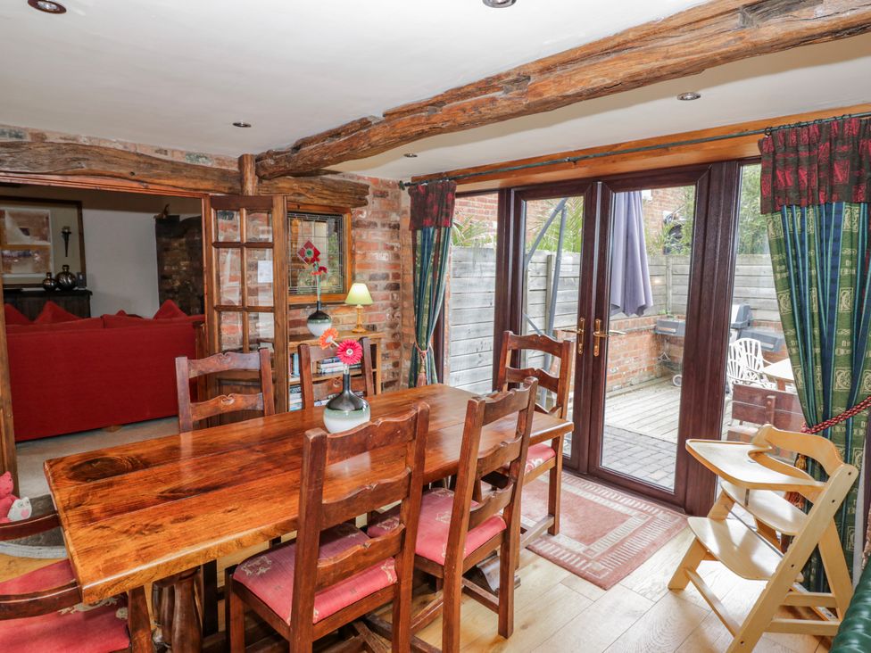 A dining room with a wooden table and chairs at The Haybarn in Lichfield