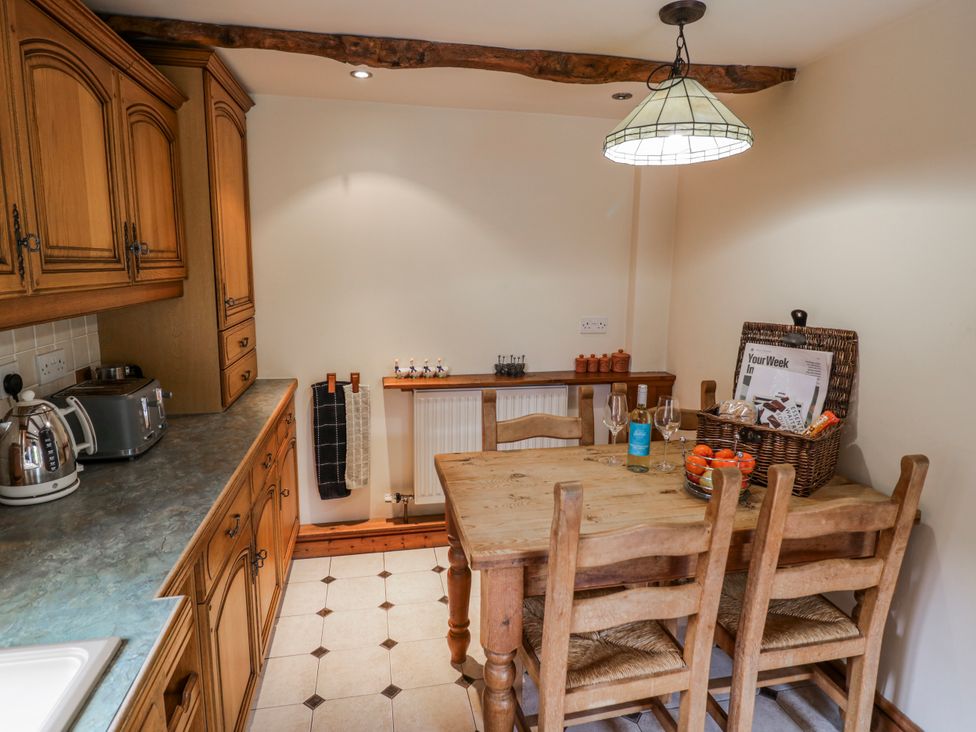 A kitchen with a wooden table and chairs at The Haybarn in Lichfield