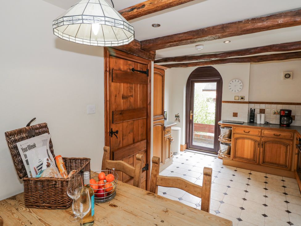 A kitchen with a dining table and door at The Haybarn in Lichfield