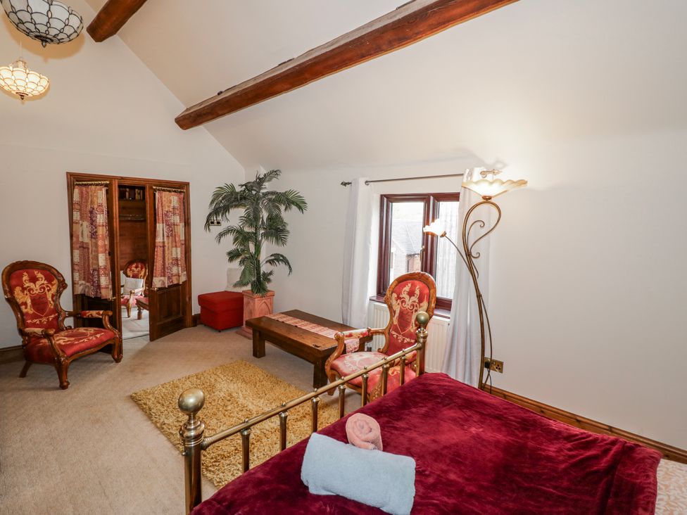 A bedroom with a bed, chairs and a table at The Haybarn in Lichfield