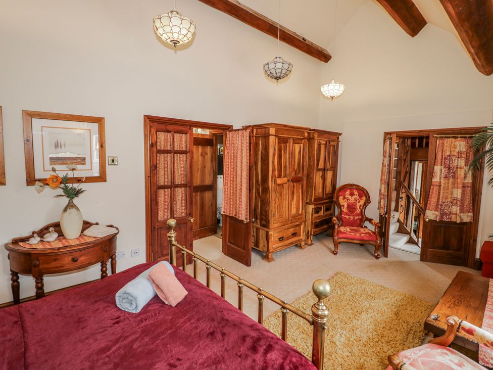 A bedroom with a bed and seating area at The Haybarn in Lichfield