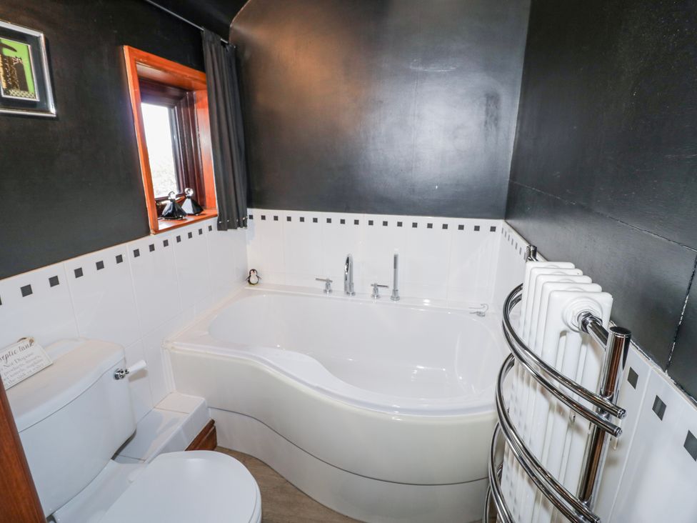 A bathroom with a bathtub and toilet at The Haybarn in Lichfield