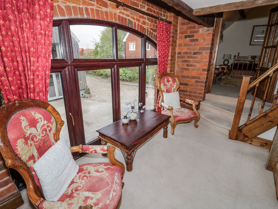 A living room with armchairs and a table at The Haybarn in Lichfield