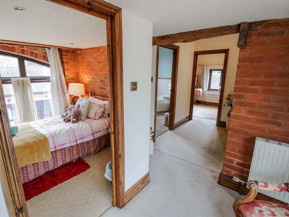 A bedroom with a bed and lamp at The Haybarn in Lichfield