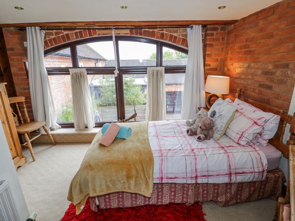 A bedroom with a bed and window at The Haybarn in Lichfield