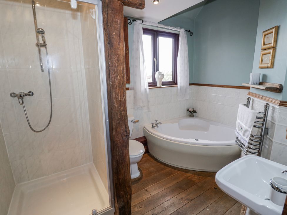 A bathroom with a shower, bathtub, toilet and sink at The Haybarn in Lichfield