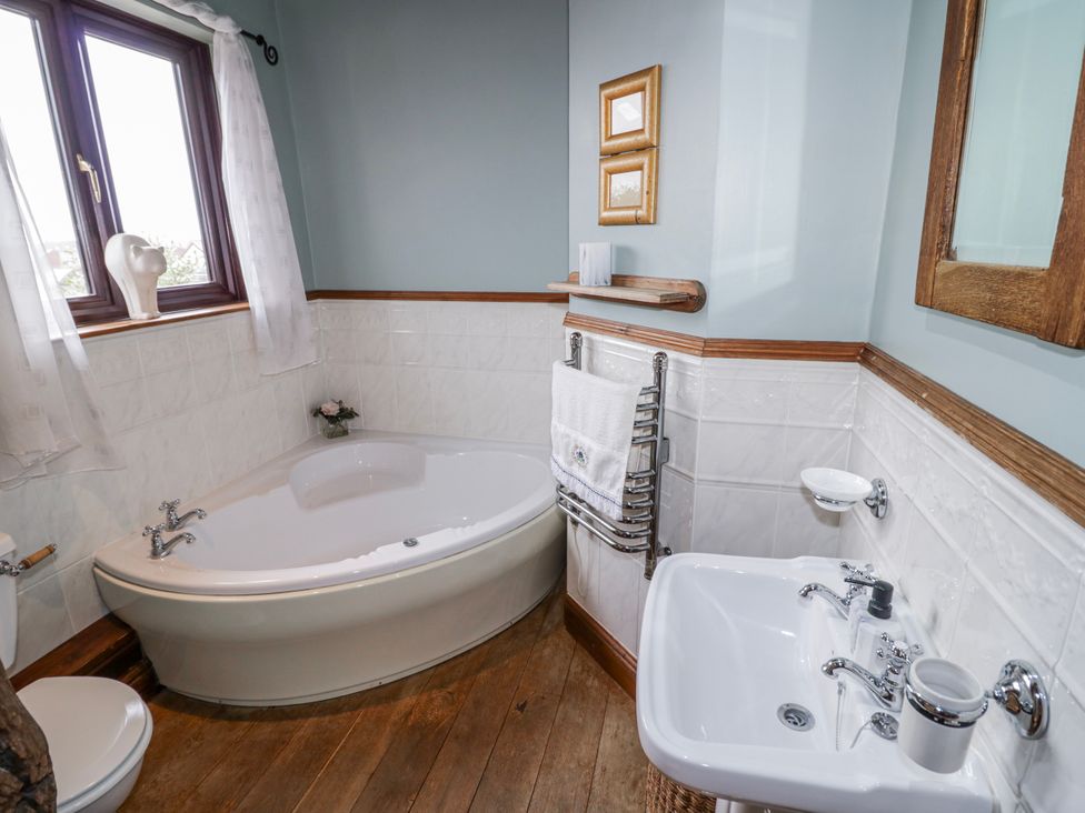 A bathroom with a bathtub, toilet, and sink at The Haybarn in Lichfield
