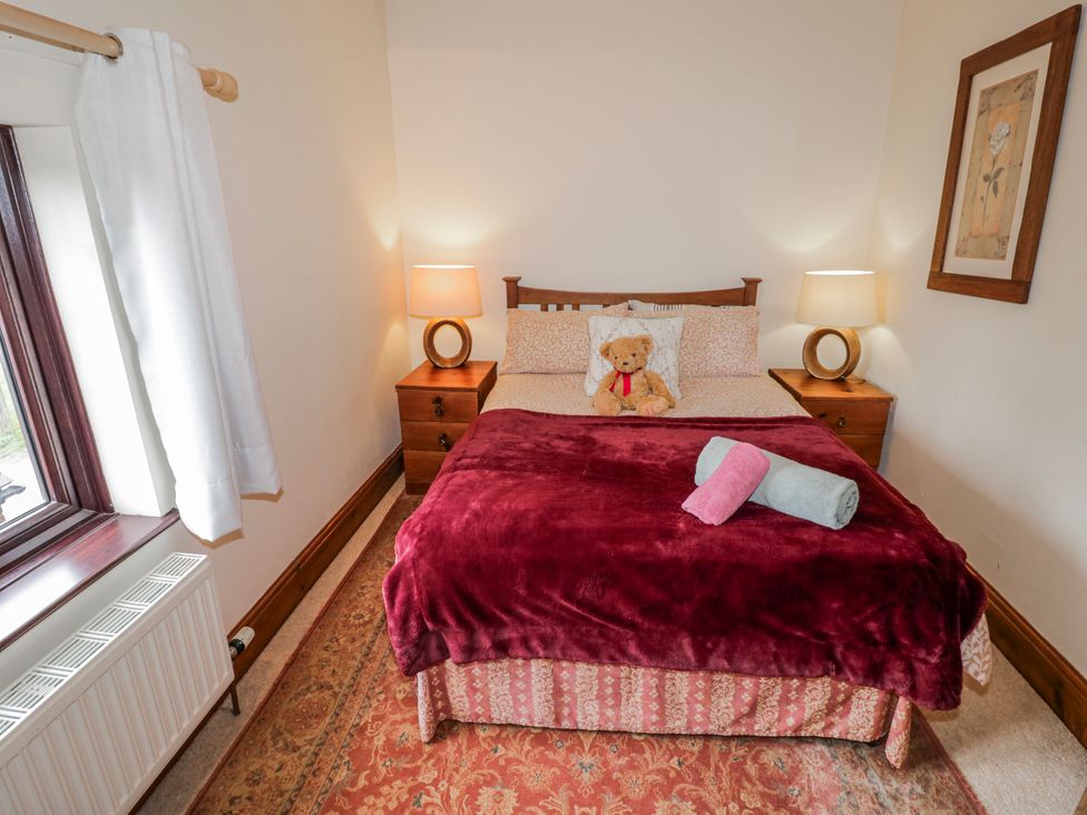A bedroom with a bed and a teddy bear at The Haybarn in Lichfield