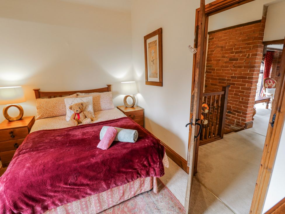 A bedroom with a bed and teddy bear at The Haybarn in Lichfield