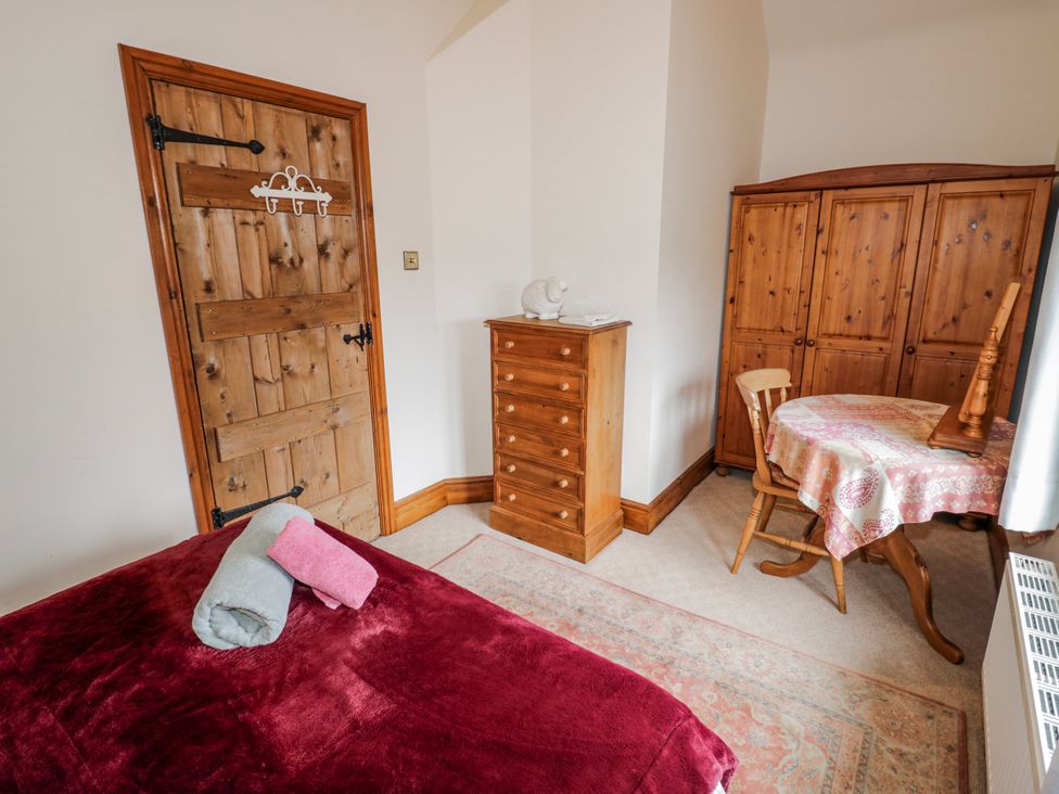A bedroom with a bed and wooden furniture at The Haybarn in Lichfield